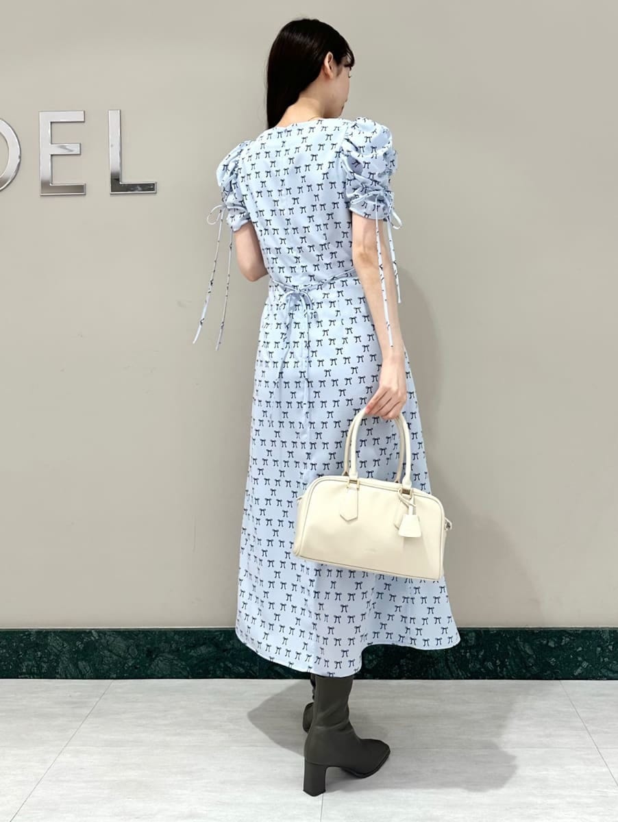 ブルー系のワンピース、ホワイト系のカーディガン/ボレロ、ホワイト系のボストンバッグを着用したレディースの冬コーディネートの4枚目の写真