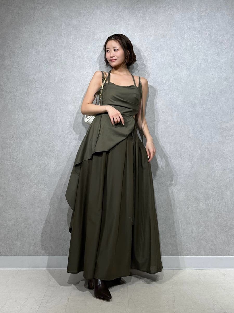 ブラウン系のブーツ、グリーン系のワンピース、ホワイト系のショルダーバッグを着用したレディースの春コーディネートの2枚目の写真