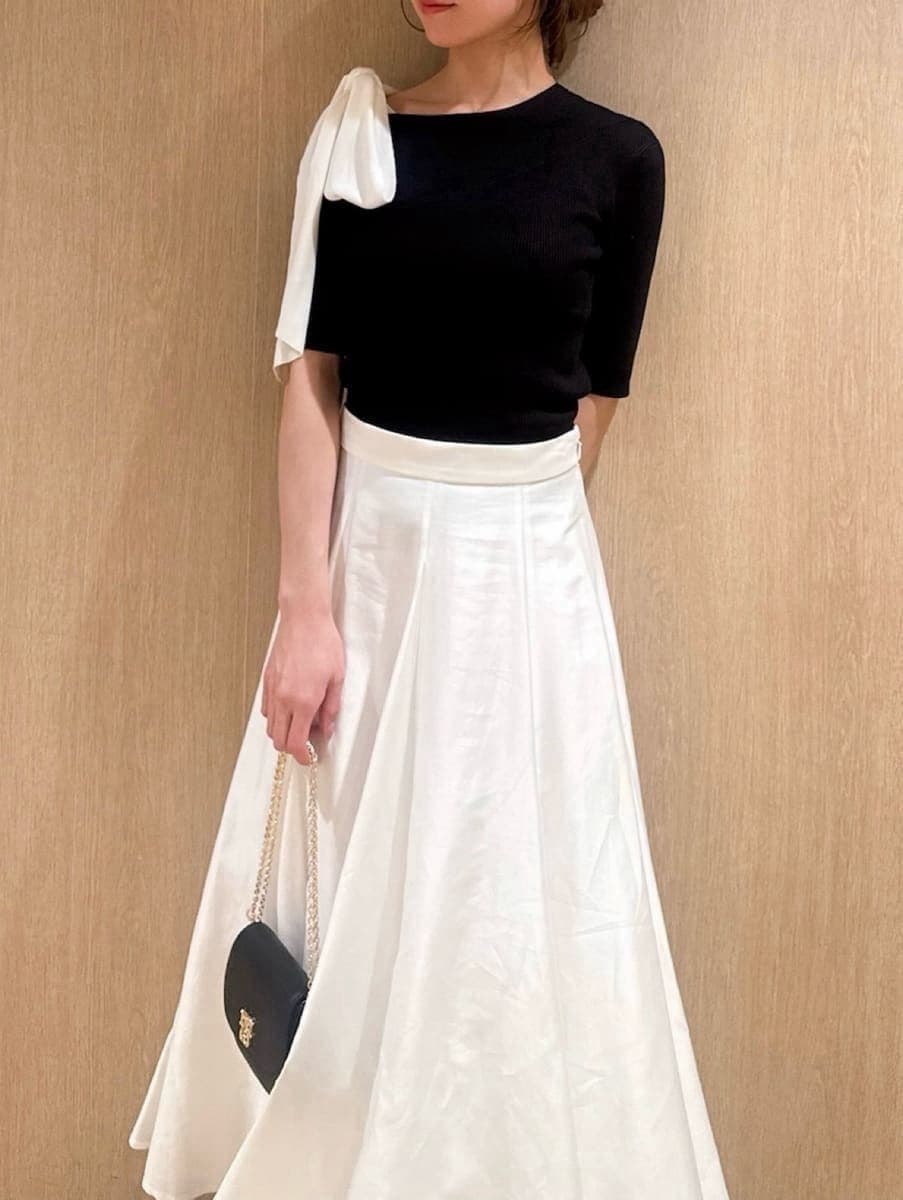 ブラック系のパンプス、ブラック系のショルダーバッグ、ブラック系のニット/セーターを着用したレディースの春コーディネートの3枚目の写真