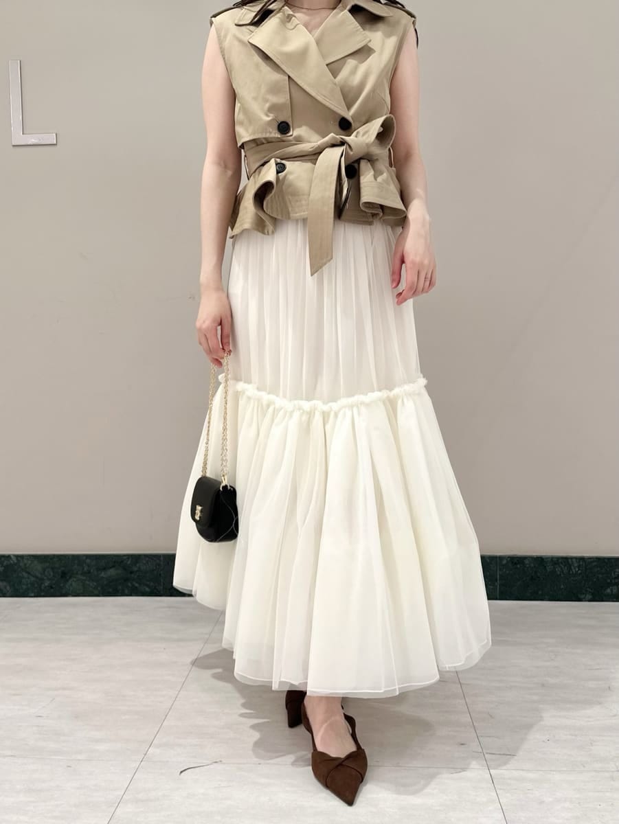 ベージュ系のワンピース、ブラウン系のパンプス、ブラック系のショルダーバッグを着用したレディースの春コーディネートの2枚目の写真