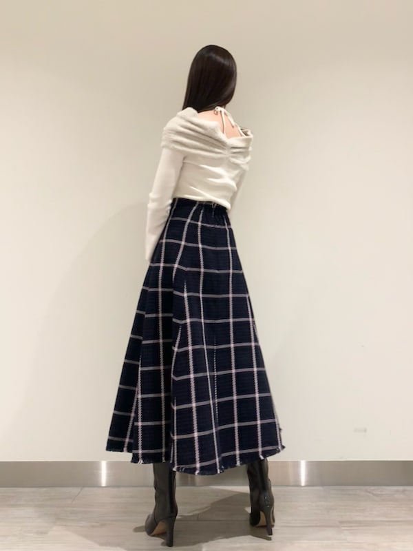 ブルー系のスカート、ホワイト系のニット/セーター、グレー系のブーツを着用したレディースの冬コーディネートの2枚目の写真