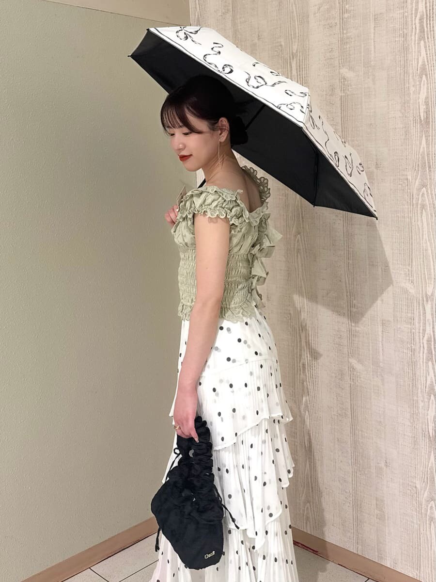 その他のスカート、グリーン系のシャツ/ブラウス、ホワイト系の折りたたみ傘を着用したレディースの春コーディネートの7枚目の写真