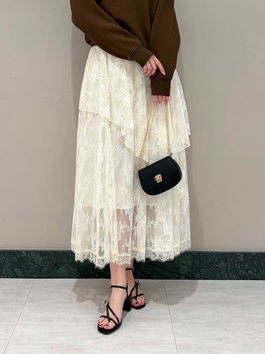 ホワイト系のスカート、ブラウン系のスウェット、ブラック系のショルダーバッグを着用したレディースの春コーディネートの5枚目の写真