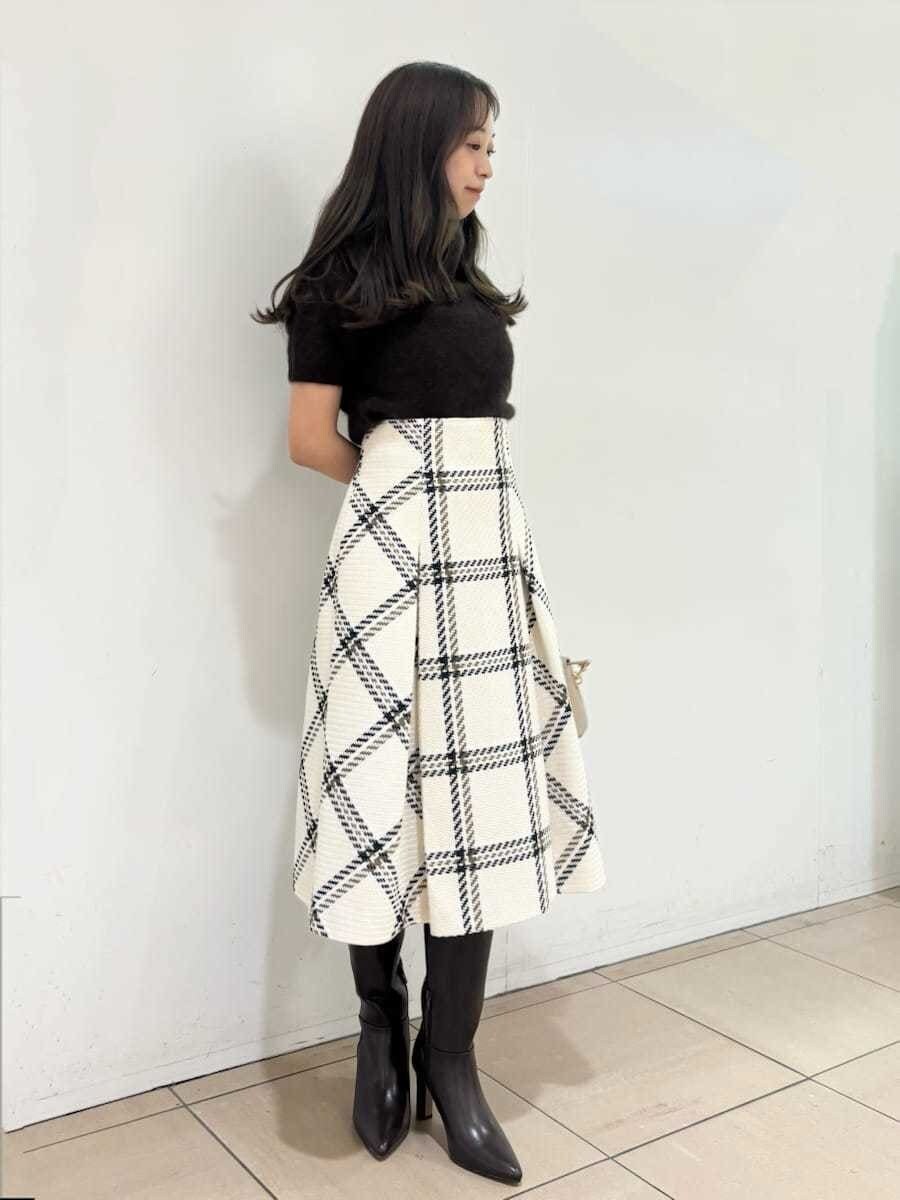 ブラウン系のニット/セーター、ホワイト系のスカート、ブラウン系のブーツを着用したレディースの秋コーディネートの4枚目の写真