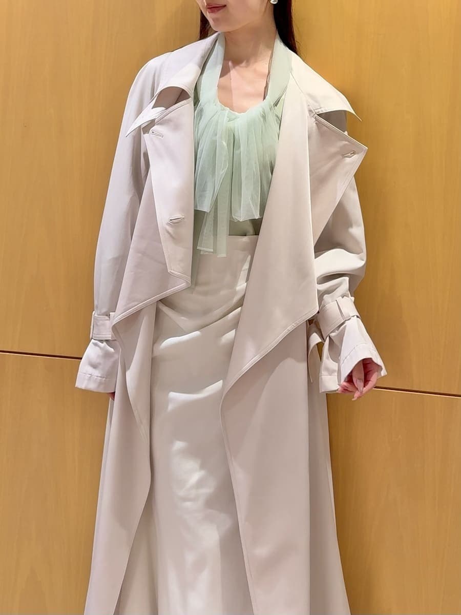 ブラック系のブーツ、ホワイト系のトレンチコート、ホワイト系のスカートを着用したレディースの冬コーディネートの6枚目の写真