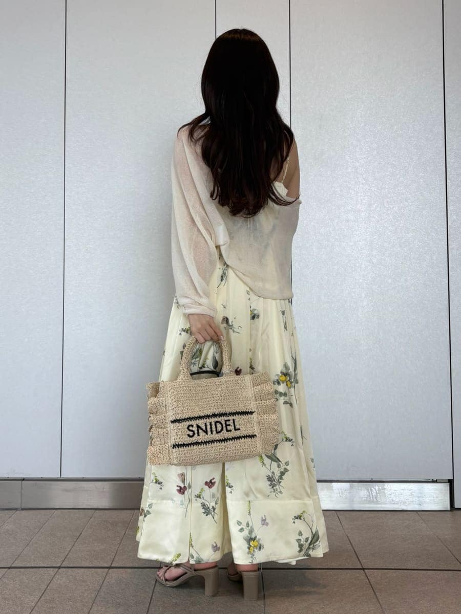 イエロー系のワンピース、ホワイト系のカーディガン/ボレロ、ベージュ系のショルダーバッグを着用したレディースの春コーディネートの4枚目の写真