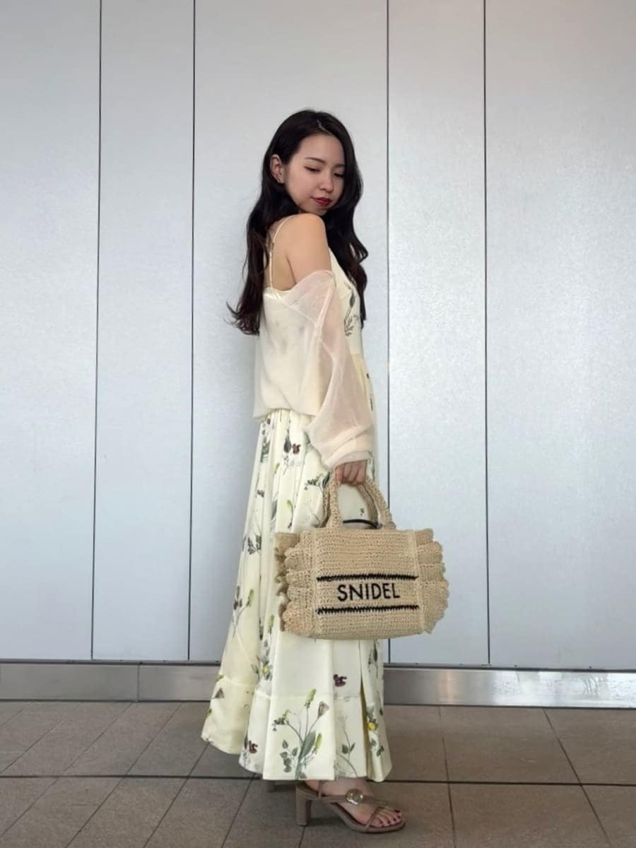 イエロー系のワンピース、ホワイト系のカーディガン/ボレロ、ベージュ系のショルダーバッグを着用したレディースの春コーディネートの5枚目の写真