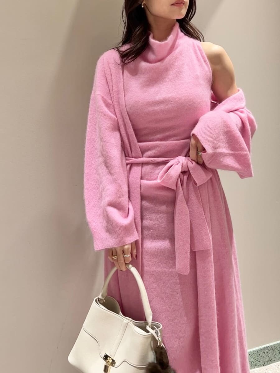 レッド系のブーツ、ピンク系のチェスターコート、ピンク系のワンピースを着用したレディースの冬コーディネートの5枚目の写真