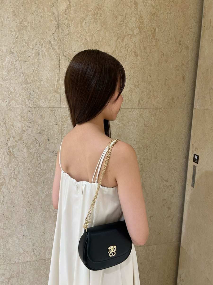 ホワイト系のサンダル、ブラック系のショルダーバッグ、ホワイト系のワンピースを着用したレディースの夏コーディネートの3枚目の写真