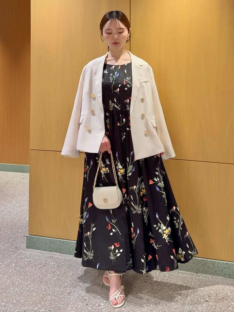 ホワイト系のテーラードジャケット、ブラック系のワンピース、ホワイト系のショルダーバッグを着用したレディースの春コーディネートの2枚目の写真