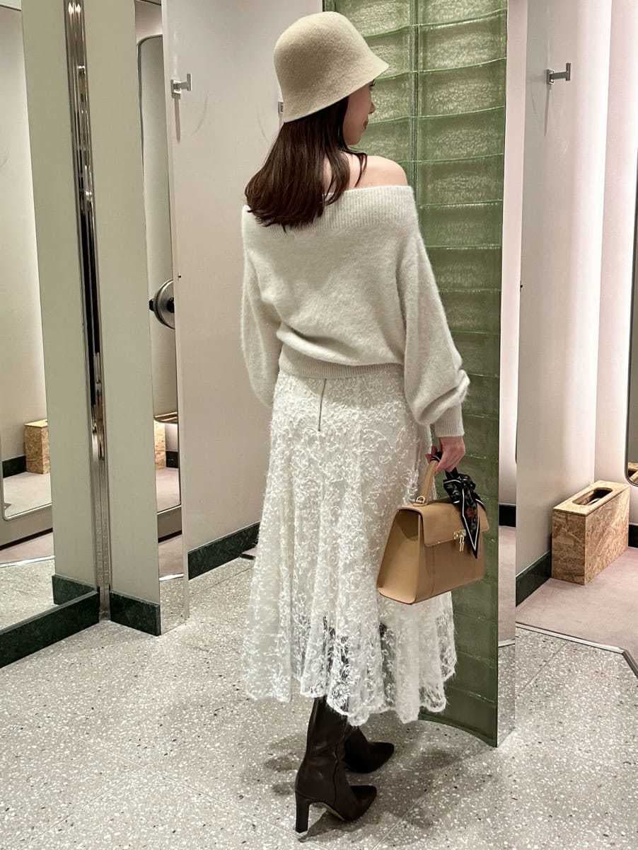 ホワイト系のニット/セーター、ホワイト系のスカート、グレー系のブーツを着用したレディースの秋コーディネートの4枚目の写真