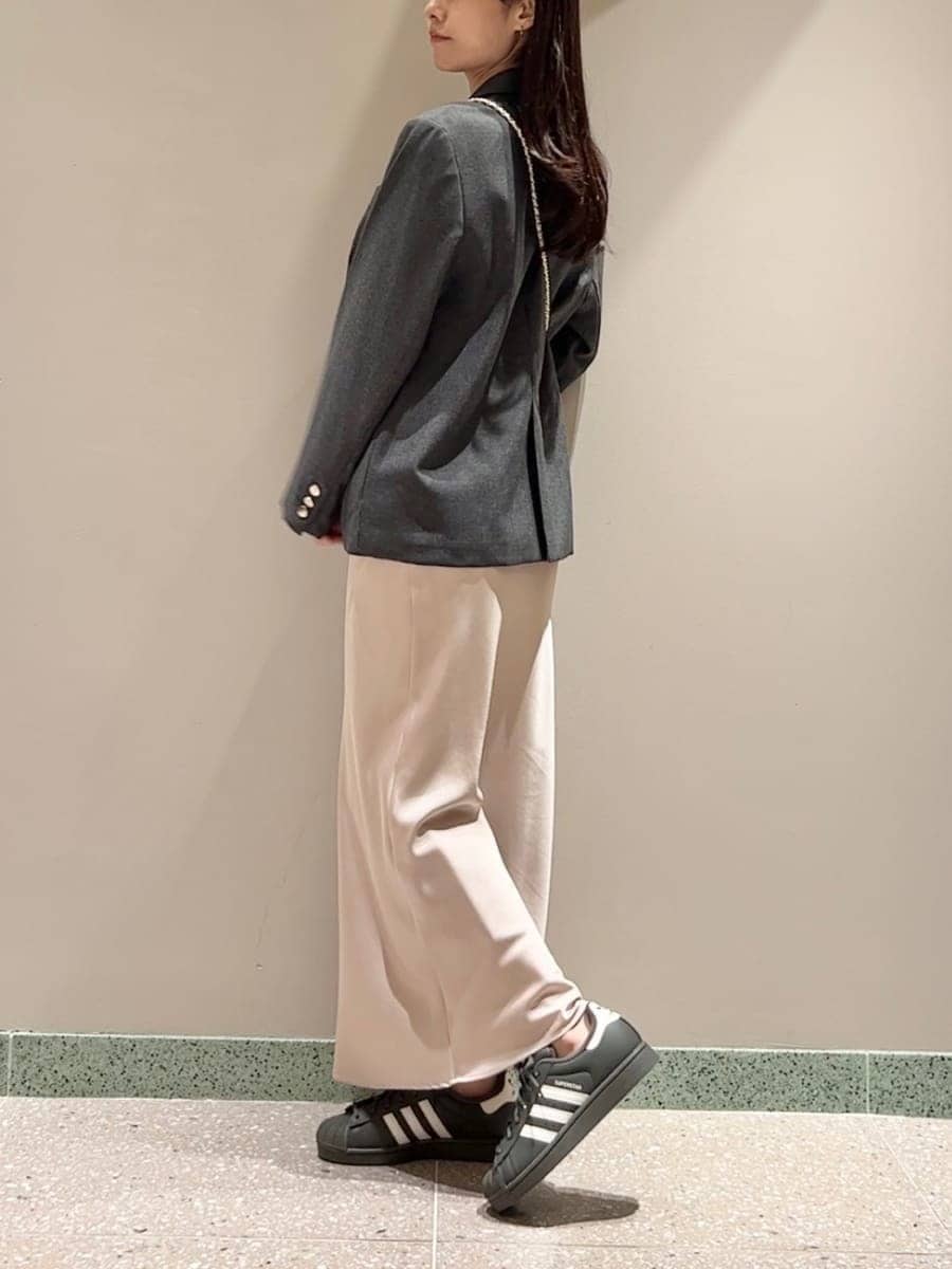 グレー系のテーラードジャケット、ホワイト系のショルダーバッグを着用したレディースの秋コーディネートの2枚目の写真