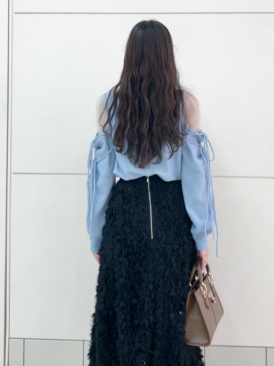 ブラック系のブーツ、ブラック系のスカート、ブルー系のニット/セーターを着用したレディースの冬コーディネートの7枚目の写真