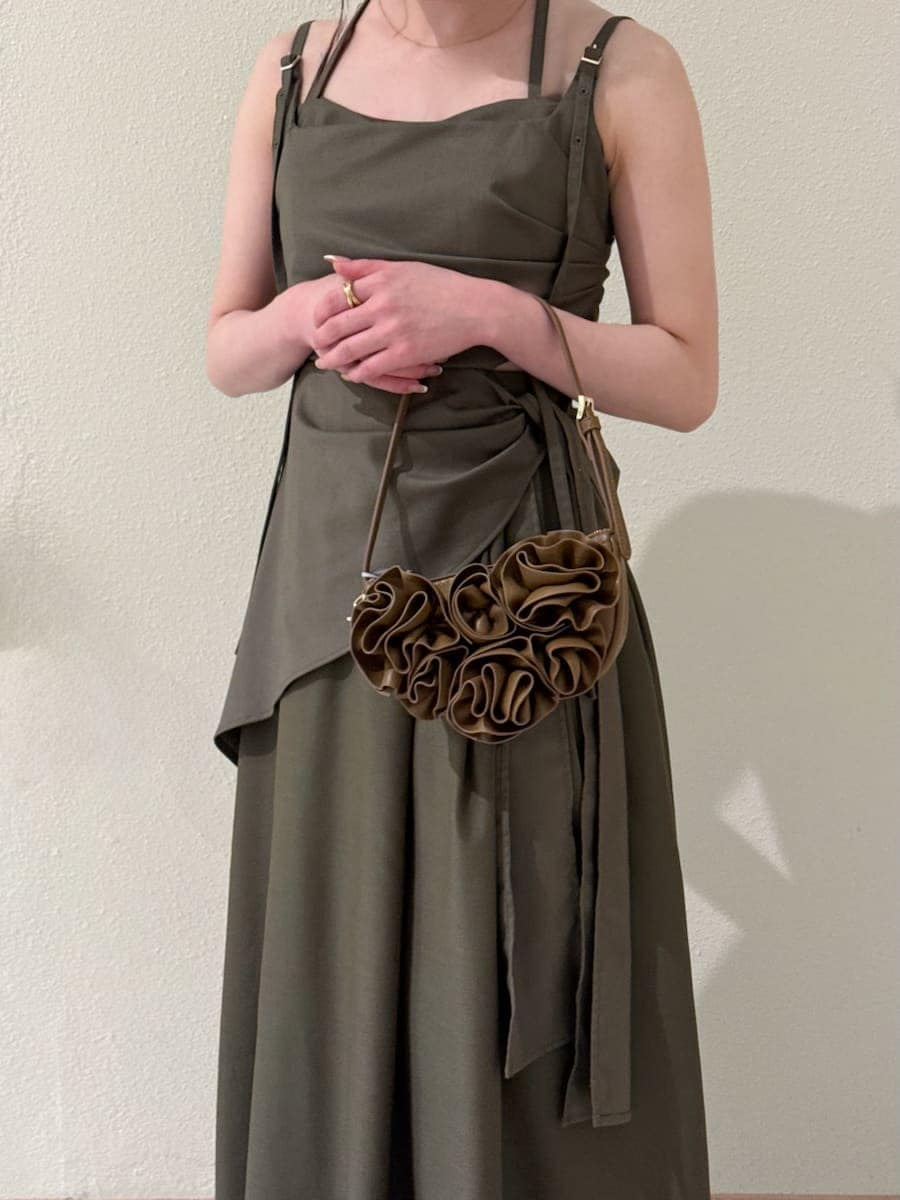 グリーン系のワンピース、ホワイト系のカーディガン/ボレロ、ブラウン系のハンドバッグを着用したレディースの春コーディネートの6枚目の写真