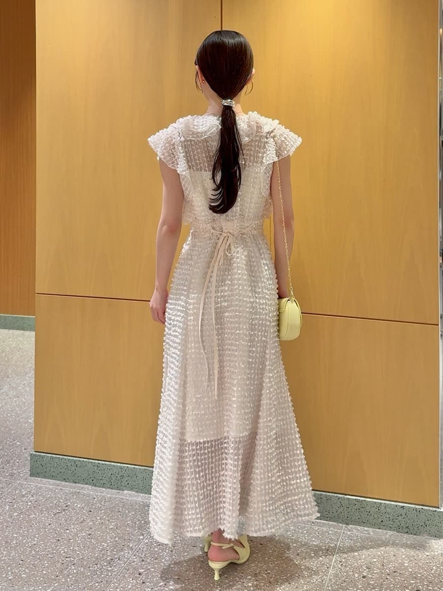 ホワイト系のドレス、イエロー系のパンプス、イエロー系のショルダーバッグを着用したレディースの春コーディネートの3枚目の写真