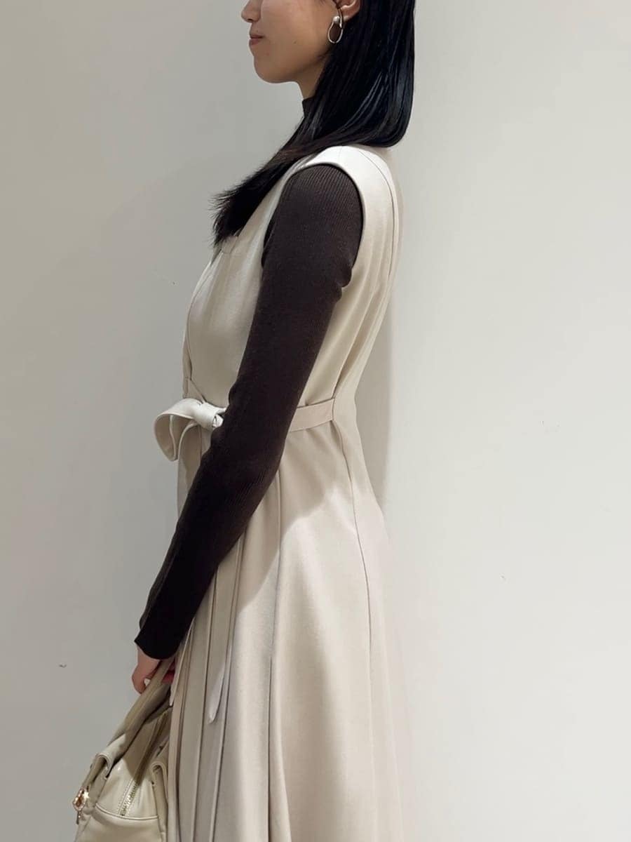 ブラウン系のステンカラーコート、ベージュ系のワンピース、ブラウン系のニット/セーターを着用したレディースの秋コーディネートの7枚目の写真