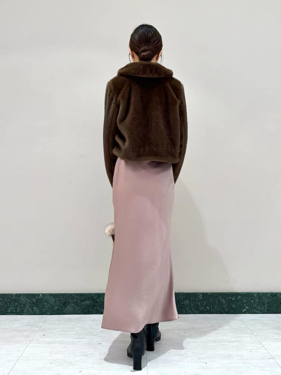 ブラウン系のステンカラーコート、ブラウン系のワンピース、ブラウン系のハンドバッグを着用したレディースの秋コーディネートの2枚目の写真