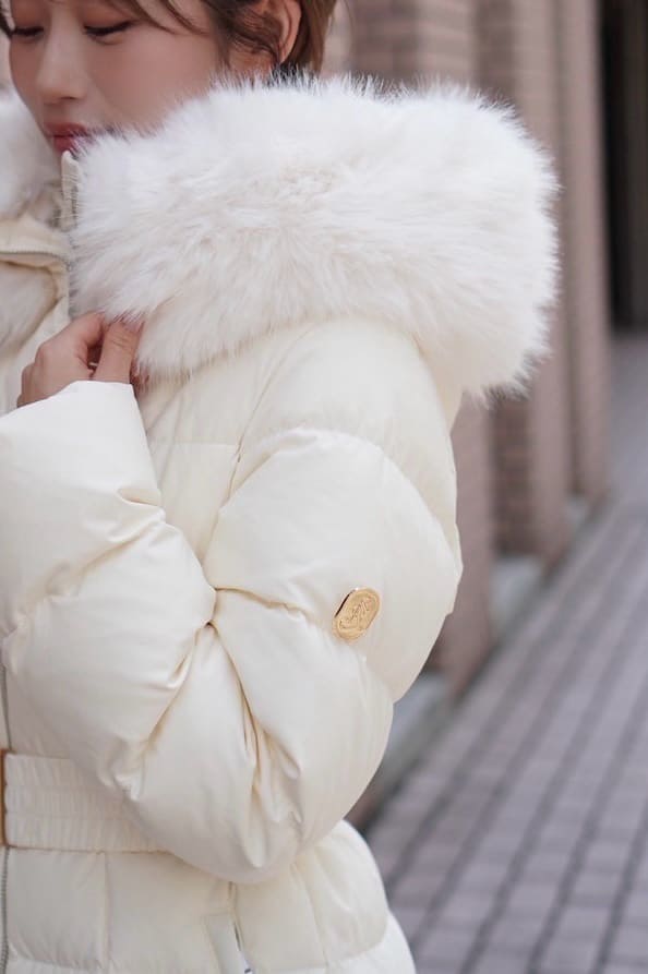 ブラック系のブーツ、ブラック系のボストンバッグ、ホワイト系のダウンジャケット/コートを着用したレディースの秋コーディネートの5枚目の写真