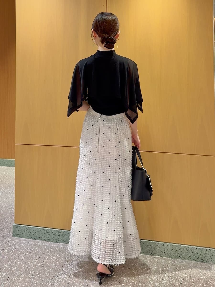 ブラック系のパンプス、ブラック系のハンドバッグ、その他のイヤリングを着用したレディースの春コーディネートの3枚目の写真