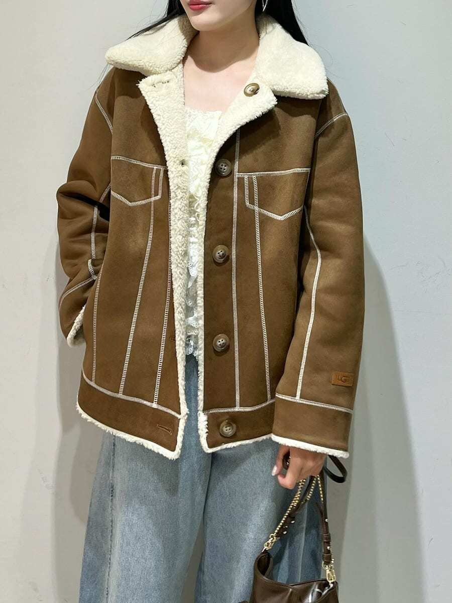 ブルー系のデニムパンツ、ブラック系のサンダル、ブラウン系のショルダーバッグを着用したレディースの秋コーディネートの3枚目の写真