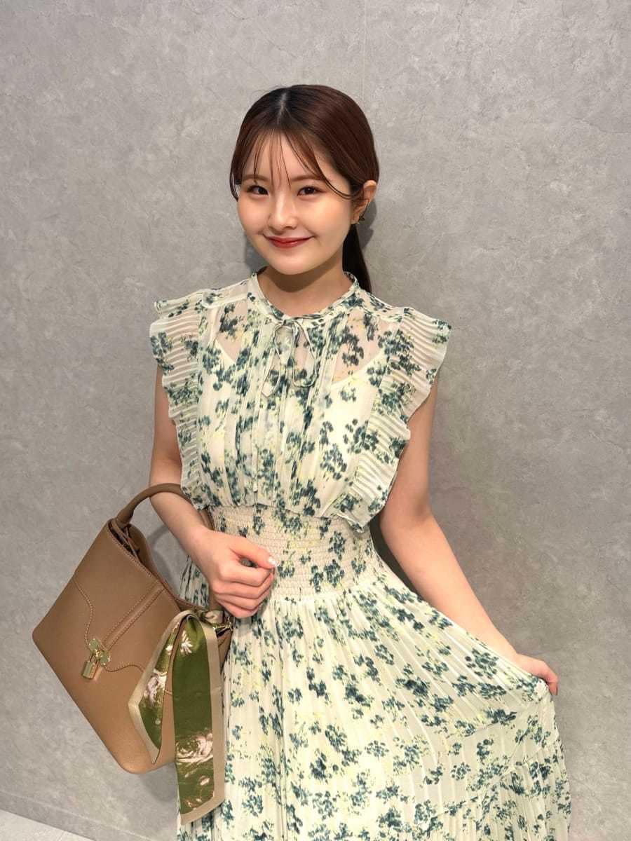 イエロー系のハンドバッグ、グリーン系のワンピース、ブラウン系のカーディガン/ボレロを着用したレディースの冬コーディネートの6枚目の写真