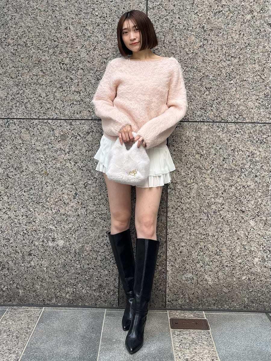 ブラック系のブーツ、ピンク系のニット/セーター、ホワイト系のその他パンツを着用したレディースの冬コーディネートの2枚目の写真