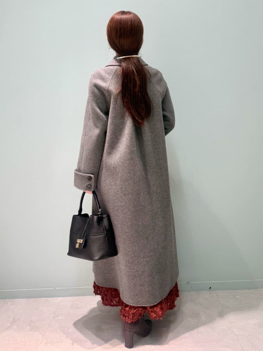 レッド系のブーツ、グレー系のチェスターコート、レッド系のスカートを着用したレディースの冬コーディネートの4枚目の写真