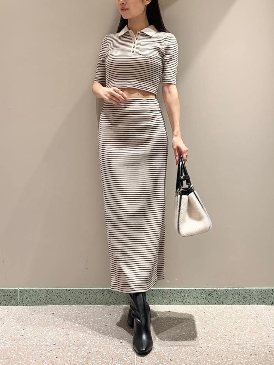 グレー系のブルゾン、ホワイト系のワンピース、ブラック系のハンドバッグを着用したレディースの秋コーディネートの6枚目の写真