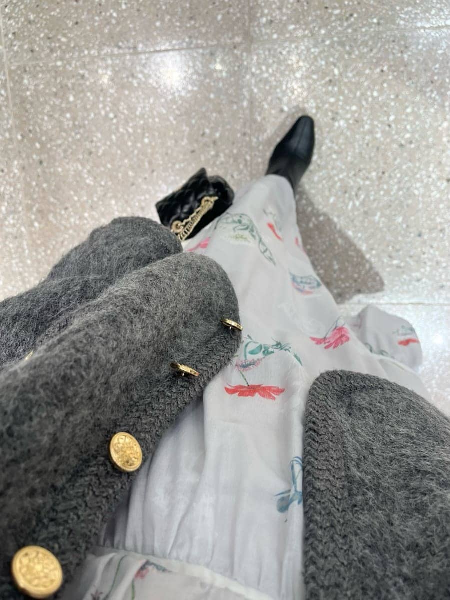 グレー系のワンピース、ブラック系のブーツ、ブラック系のショルダーバッグを着用したレディースの冬コーディネートの6枚目の写真