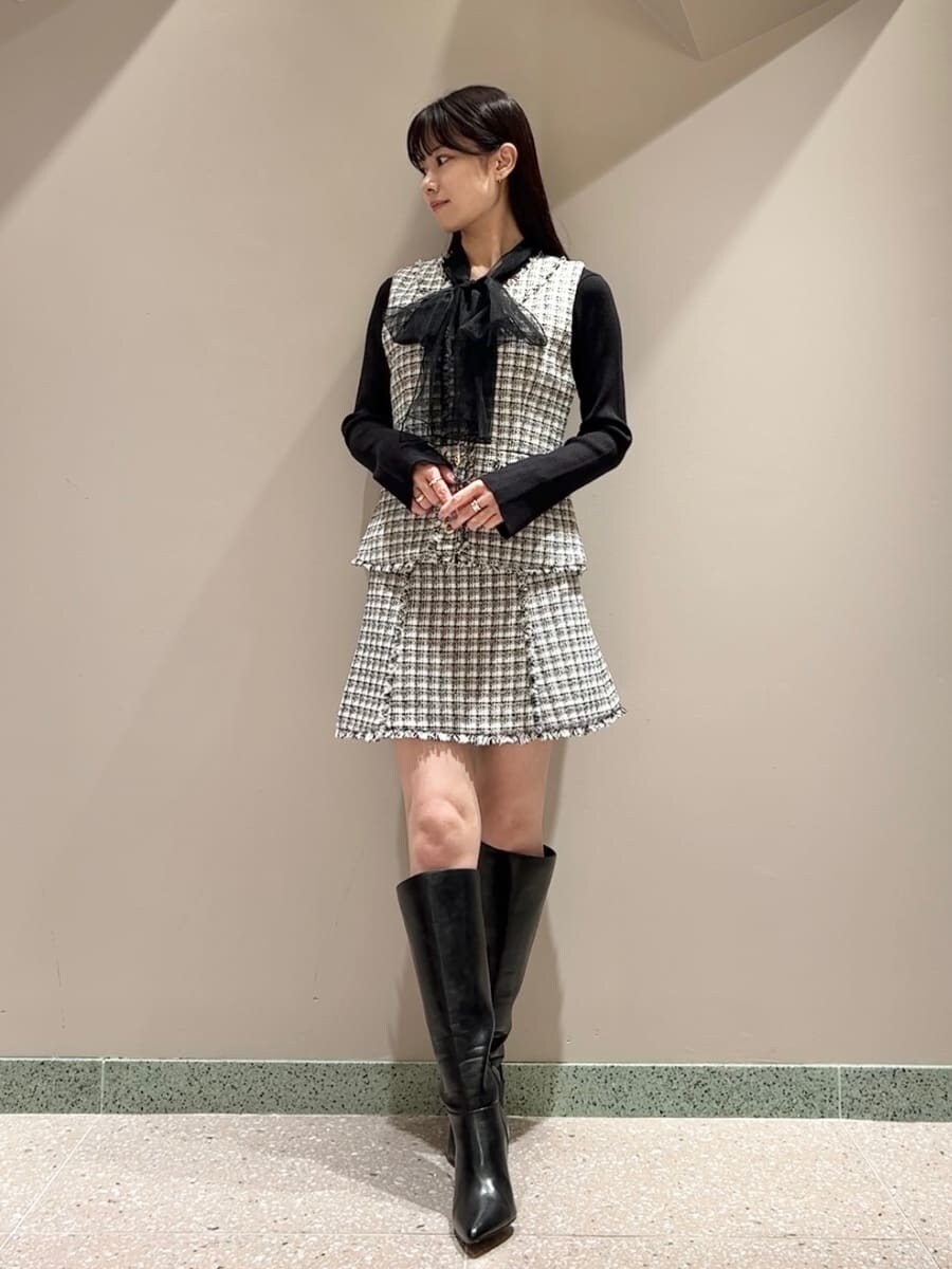 ホワイト系のその他アウター、ブラック系のニット/セーター、ホワイト系のスカートを着用したレディースの秋コーディネートの2枚目の写真