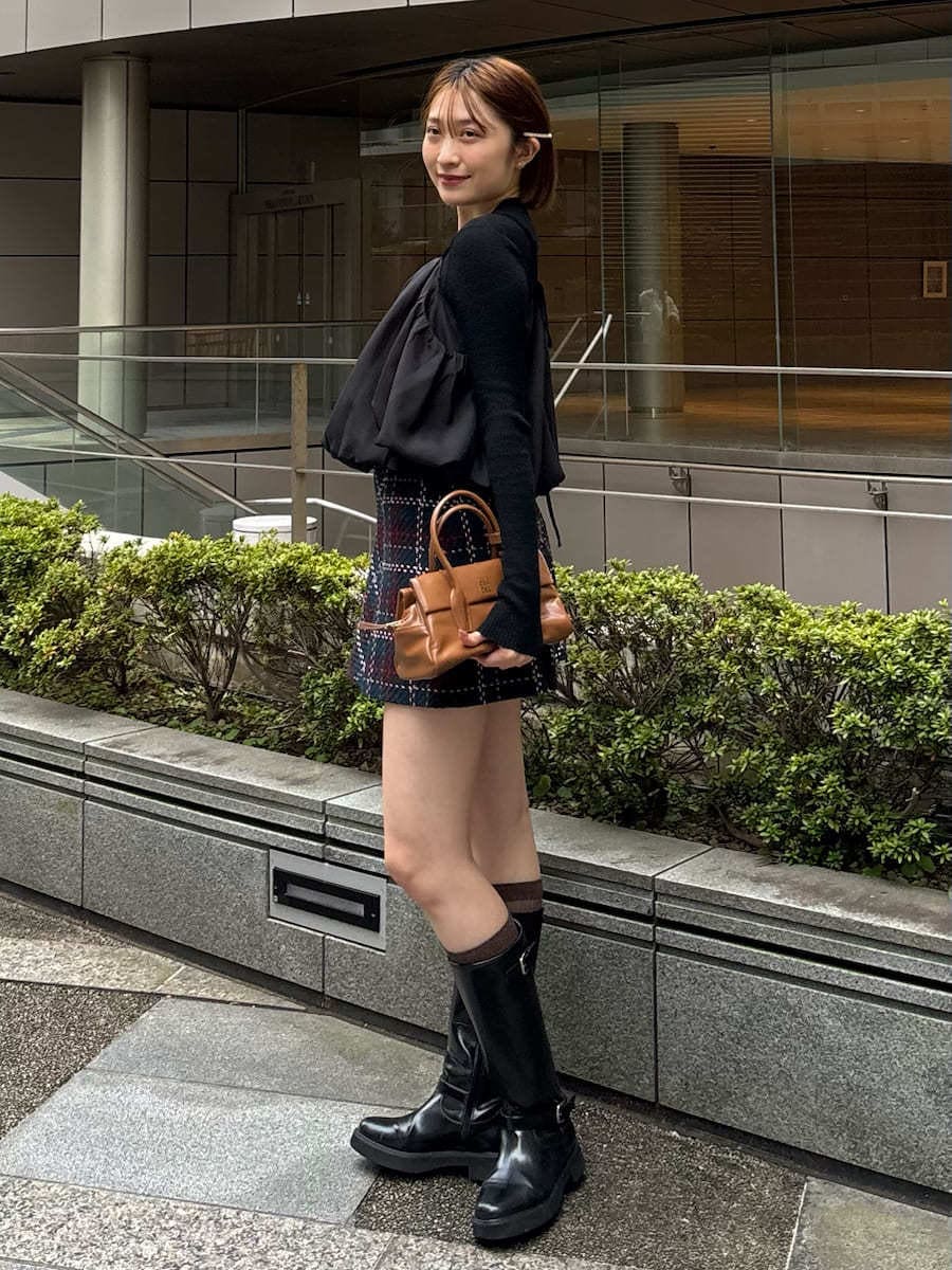 ブラック系のブーツ、ブルー系のその他パンツ、ブラック系のニット/セーターを着用したレディースの秋コーディネートの6枚目の写真