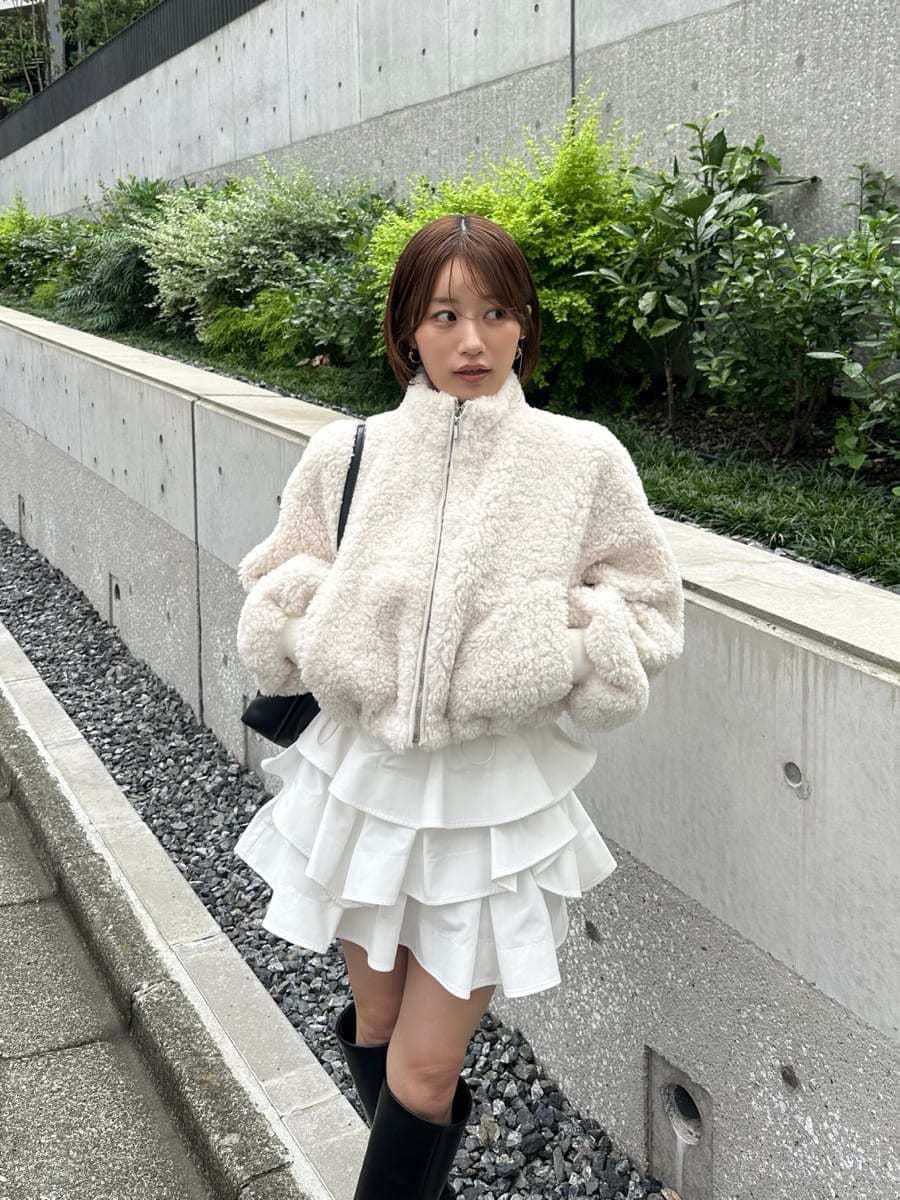 ホワイト系のその他パンツ、ブラック系のブーツ、ブラック系のショルダーバッグを着用したレディースの秋コーディネートの8枚目の写真