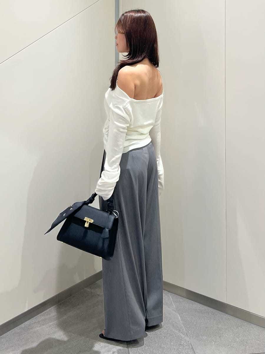 グレー系のその他パンツ、ホワイト系のニット/セーター、ブラック系のサンダルを着用したレディースの秋コーディネートの2枚目の写真