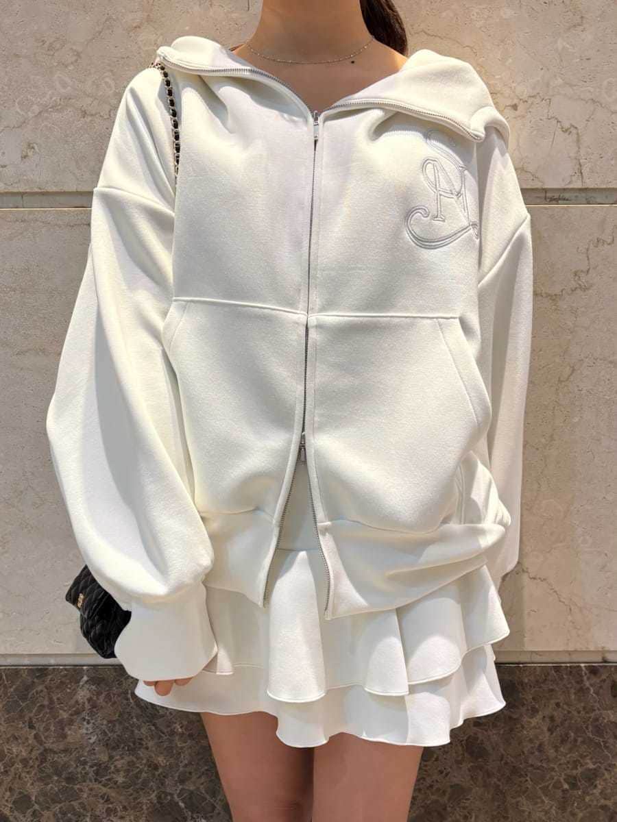 ブラウン系のブーツ、ブラック系のショルダーバッグ、ホワイト系のパーカーを着用したレディースの冬コーディネートの7枚目の写真