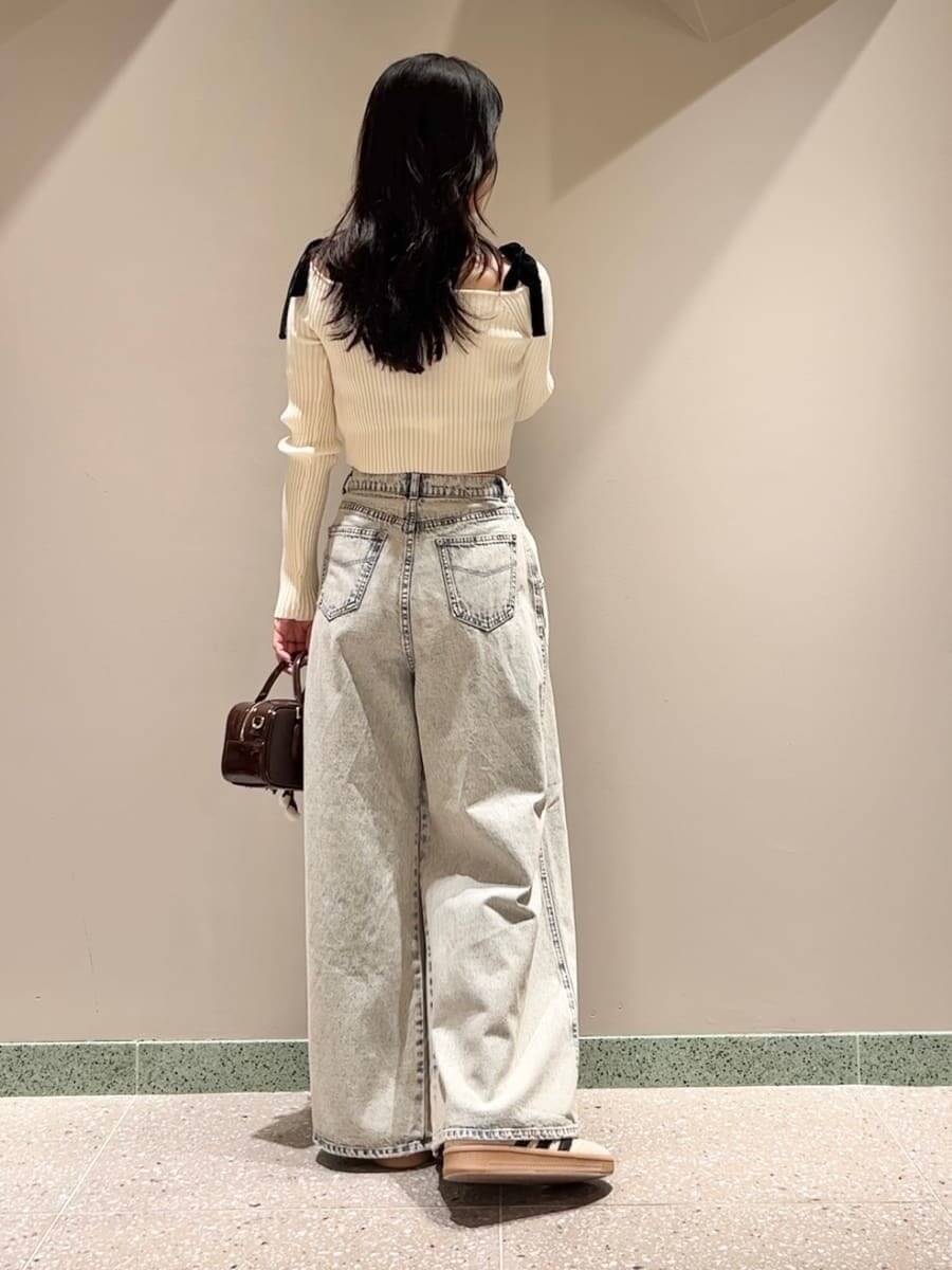 ホワイト系のニット/セーター、ブルー系のデニムパンツ、ブラウン系のボストンバッグを着用したレディースの秋コーディネートの4枚目の写真