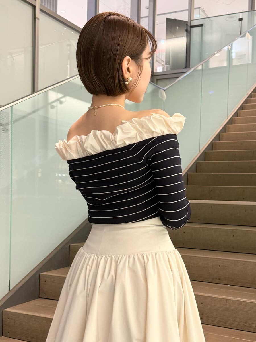 ベージュ系のトレンチコート、ホワイト系のスカート、その他のニット/セーターを着用したレディースの冬コーディネートの8枚目の写真