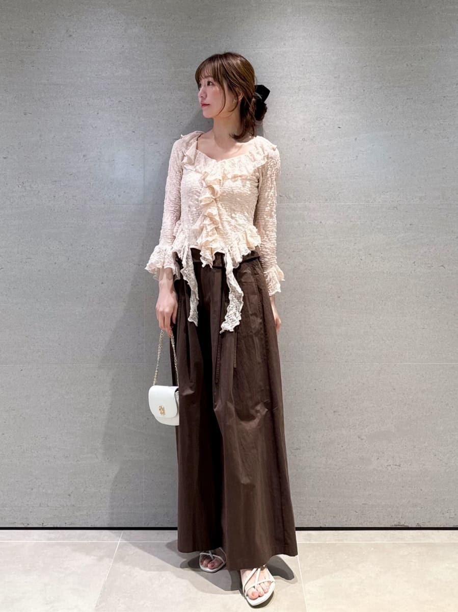 ブラウン系のその他パンツ、ピンク系のTシャツ/カットソー、ホワイト系のショルダーバッグを着用したレディースの冬コーディネートの5枚目の写真