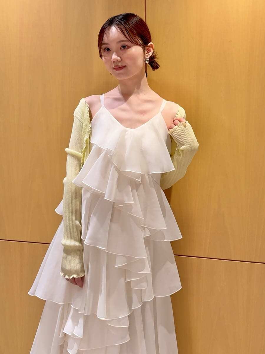 ブラウン系のかごバッグ、イエロー系のカーディガン/ボレロ、ホワイト系のドレスを着用したレディースの夏コーディネートの6枚目の写真