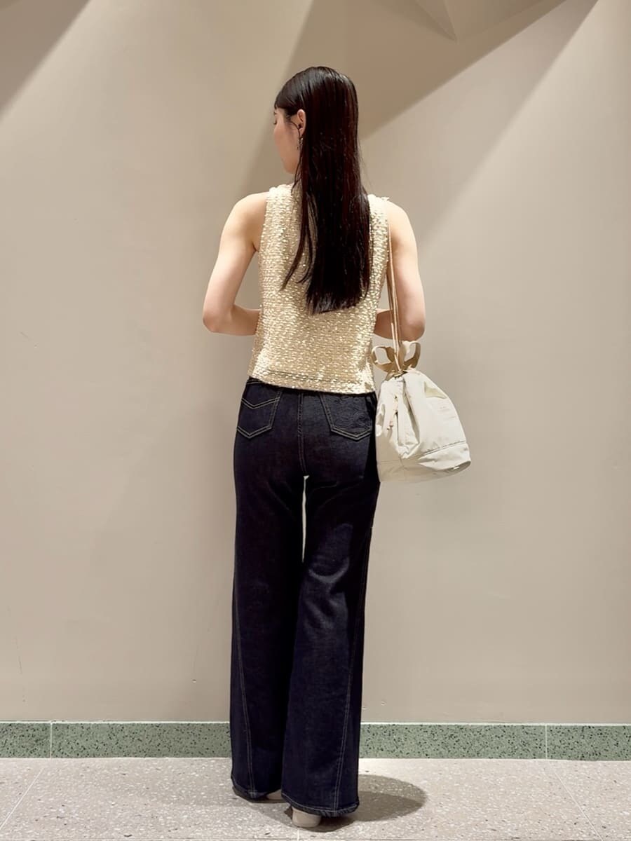 ホワイト系のタンクトップ、ブルー系のデニムパンツ、ベージュ系のハンドバッグを着用したレディースの夏コーディネートの4枚目の写真