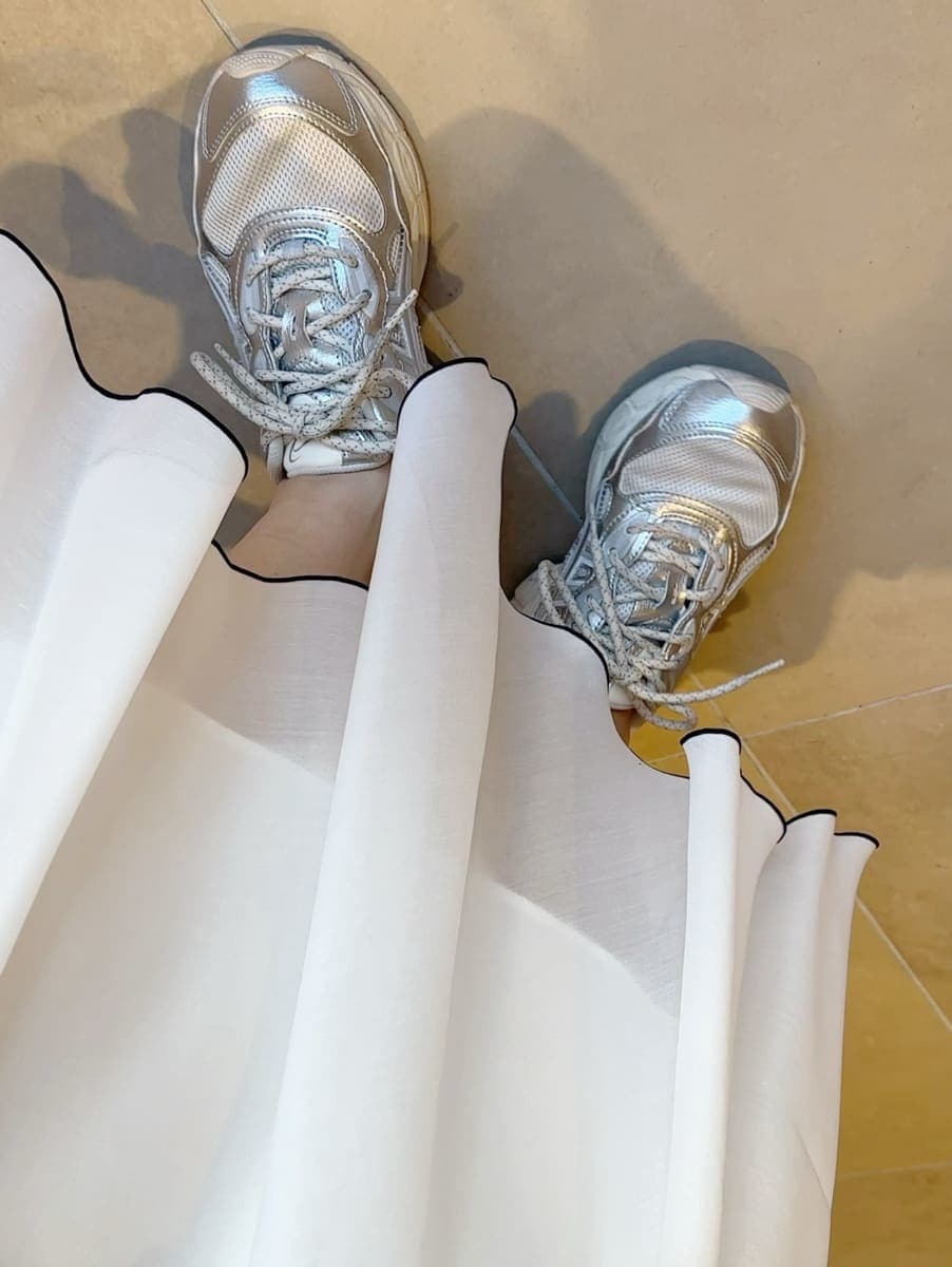 ブルー系のワンピース、ホワイト系のショルダーバッグ、シルバー系のスニーカーを着用したレディースの冬コーディネートの2枚目の写真