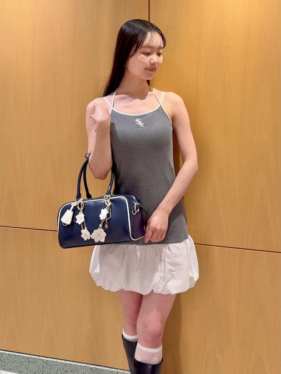 ホワイト系のブルゾン、グレー系のワンピース、ブルー系のボストンバッグを着用したレディースの春コーディネートの4枚目の写真