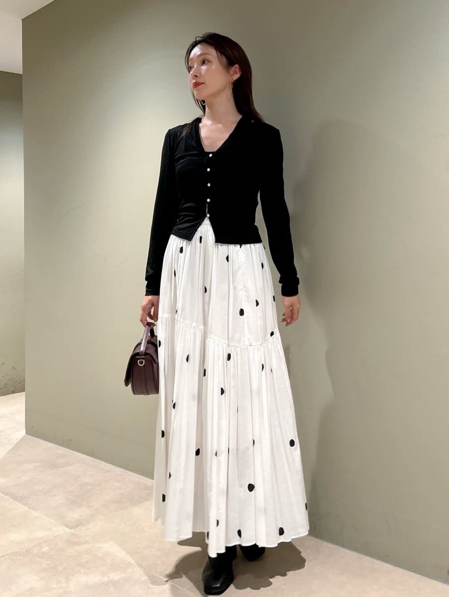 その他のスカート、ブラック系のブーツ、ブラウン系のハンドバッグを着用したレディースの秋コーディネートの3枚目の写真