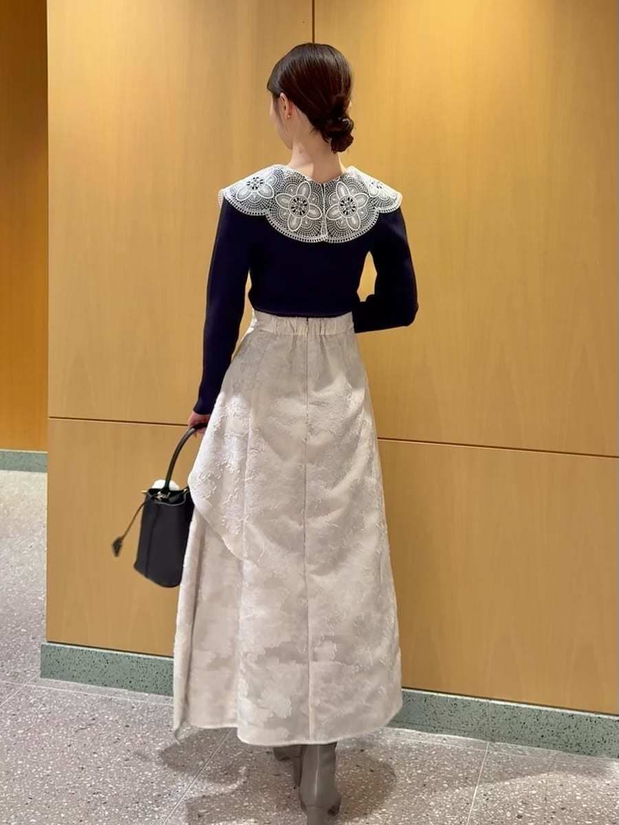 ブルー系のニット/セーター、ブラック系のハンドバッグ、ホワイト系のチャームを着用したレディースの冬コーディネートの3枚目の写真