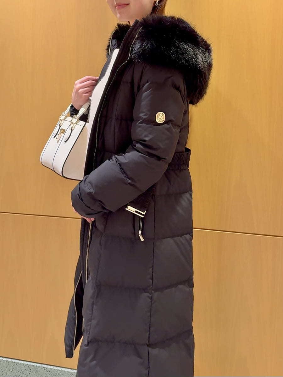 ホワイト系のワンピース、ブラック系のダウンジャケット/コート、ホワイト系のハンドバッグを着用したレディースの冬コーディネートの7枚目の写真