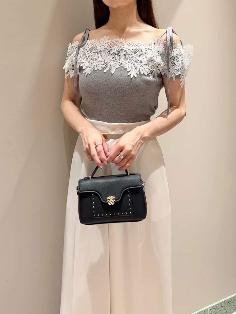 グレー系のニット/セーター、ホワイト系のその他パンツ、ブラック系のショルダーバッグを着用したレディースの夏コーディネートの4枚目の写真