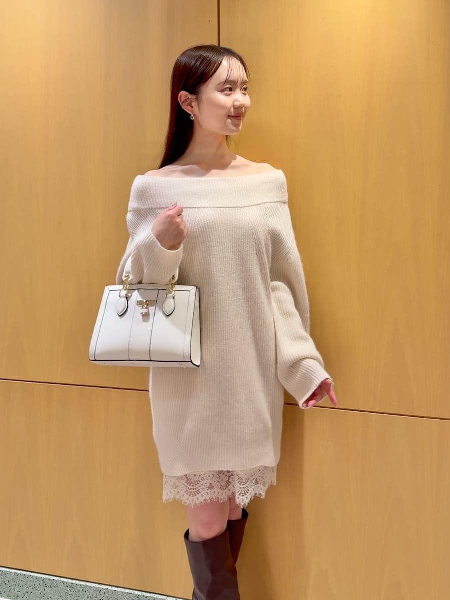 ホワイト系のワンピース、ブラック系のダウンジャケット/コート、ホワイト系のハンドバッグを着用したレディースの冬コーディネートの8枚目の写真