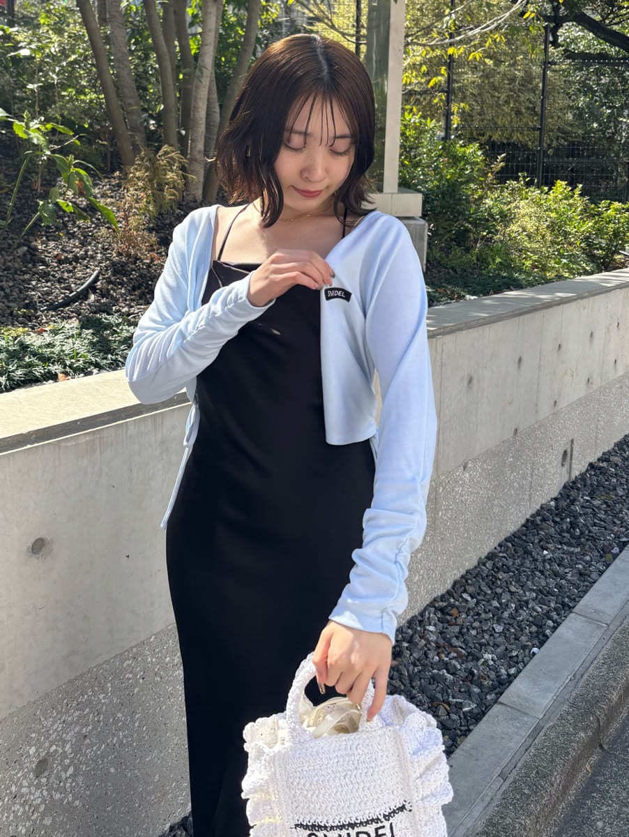 シルバー系のスニーカー、ブラック系のワンピースを着用したレディースの春コーディネートの4枚目の写真