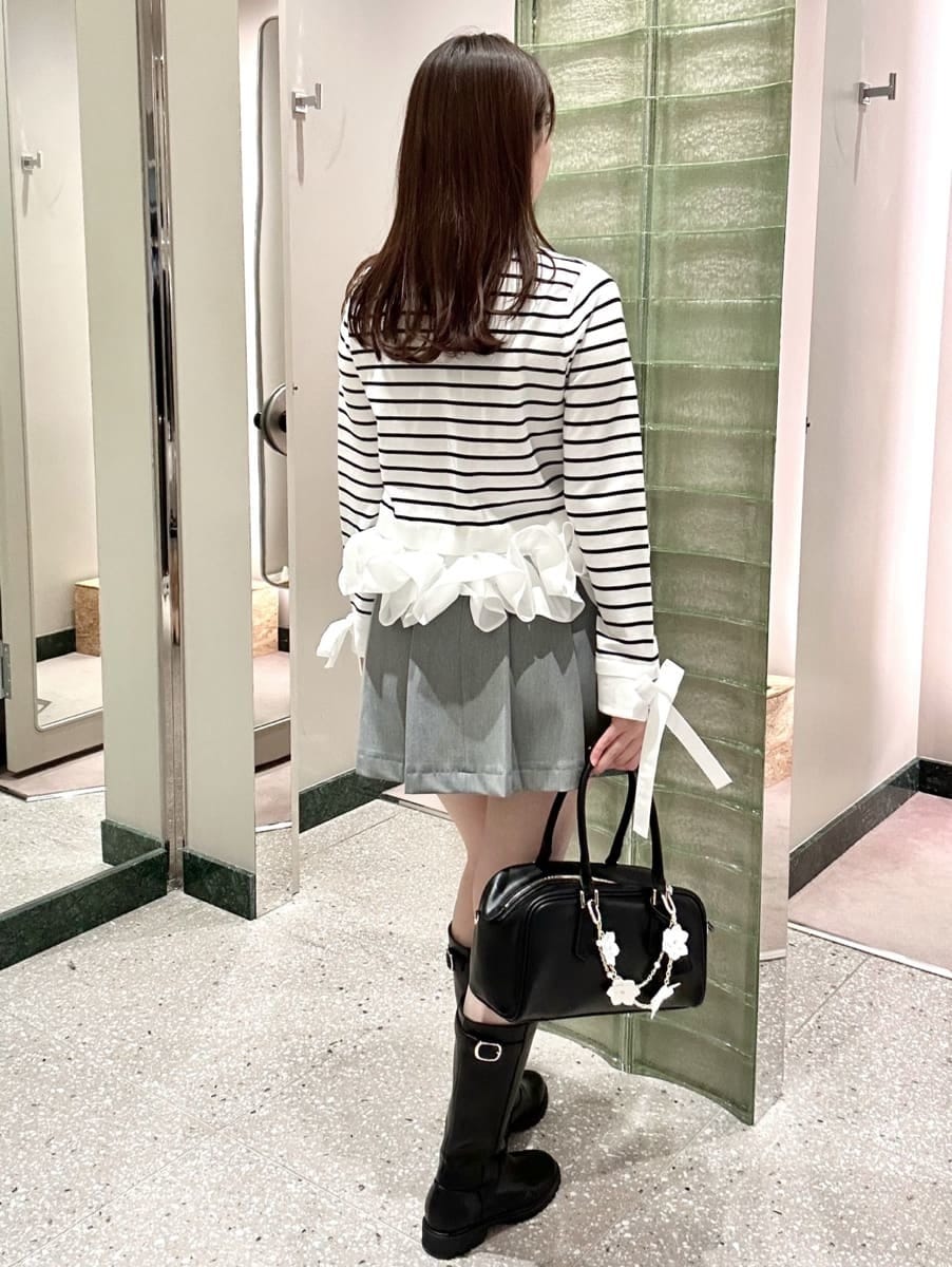 グレー系のスカート、その他のニット/セーター、ブラック系のボストンバッグを着用したレディースの冬コーディネートの4枚目の写真