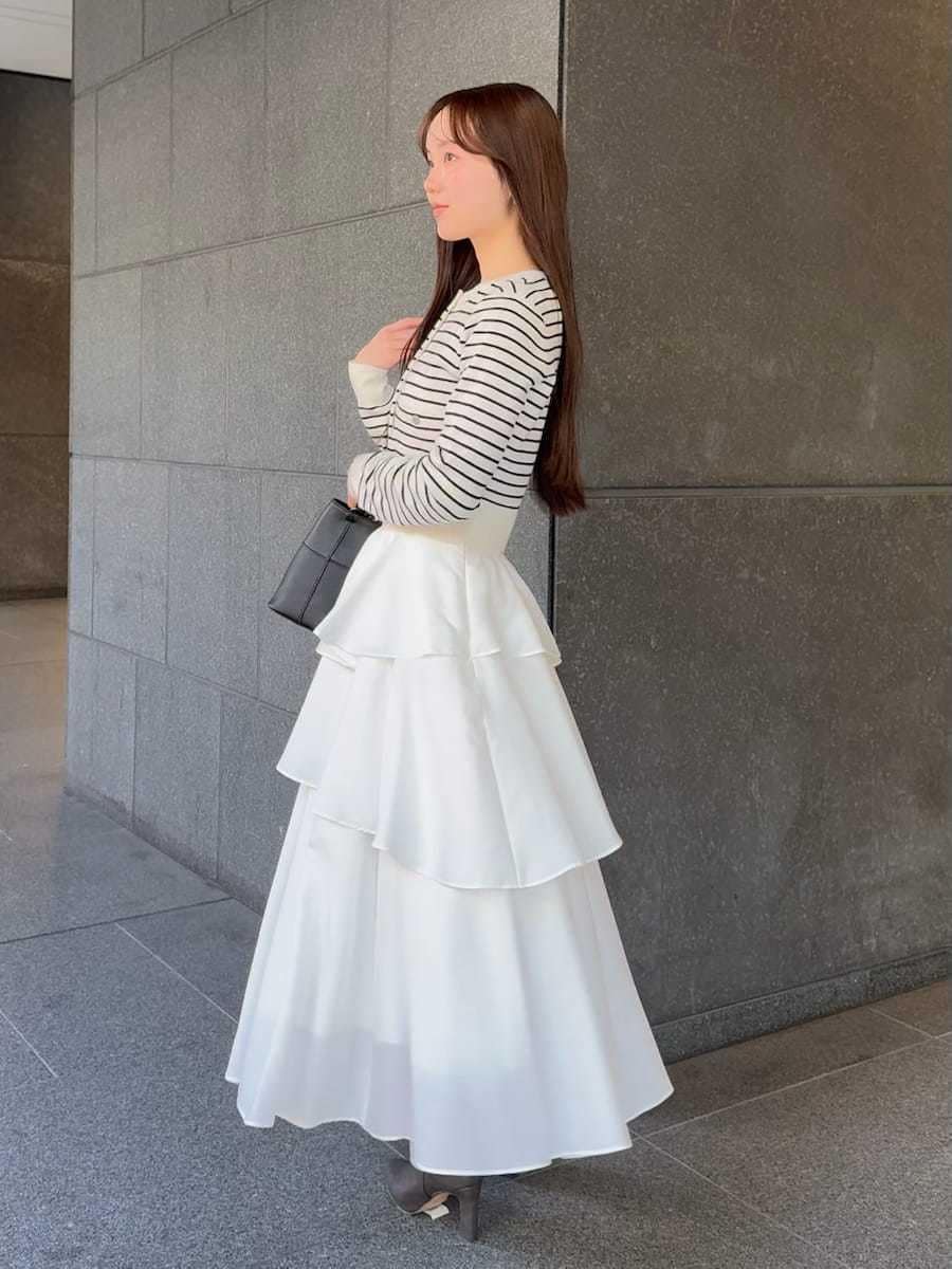 グレー系のブーツ、その他のワンピース、ブラック系のハンドバッグを着用したレディースの冬コーディネートの2枚目の写真