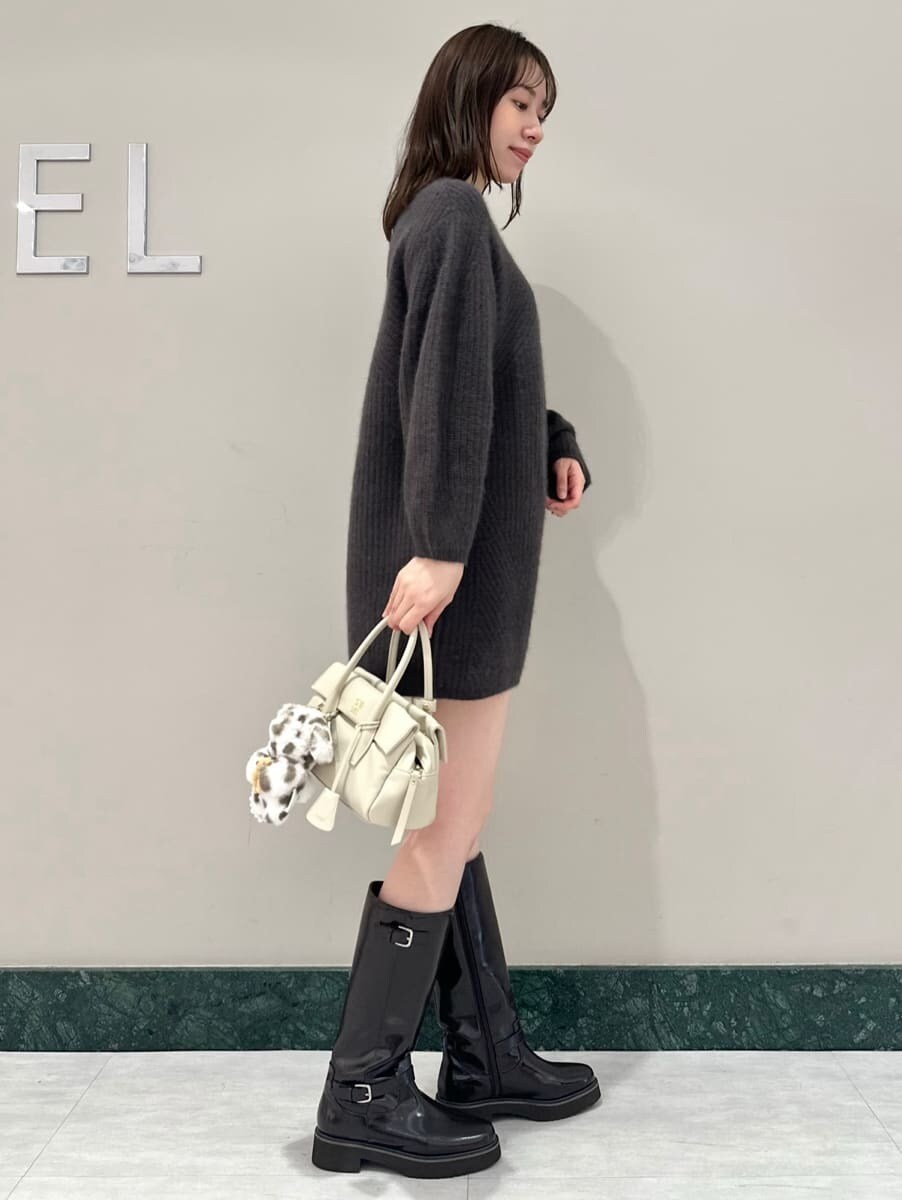 ブラウン系のブーツ、ホワイト系のボストンバッグ、グレー系のワンピースを着用したレディースの秋コーディネートの3枚目の写真